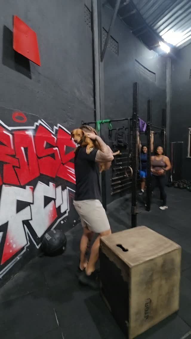 Aluno fazendo salto na caixa ao lado do grafite da Cross FC
